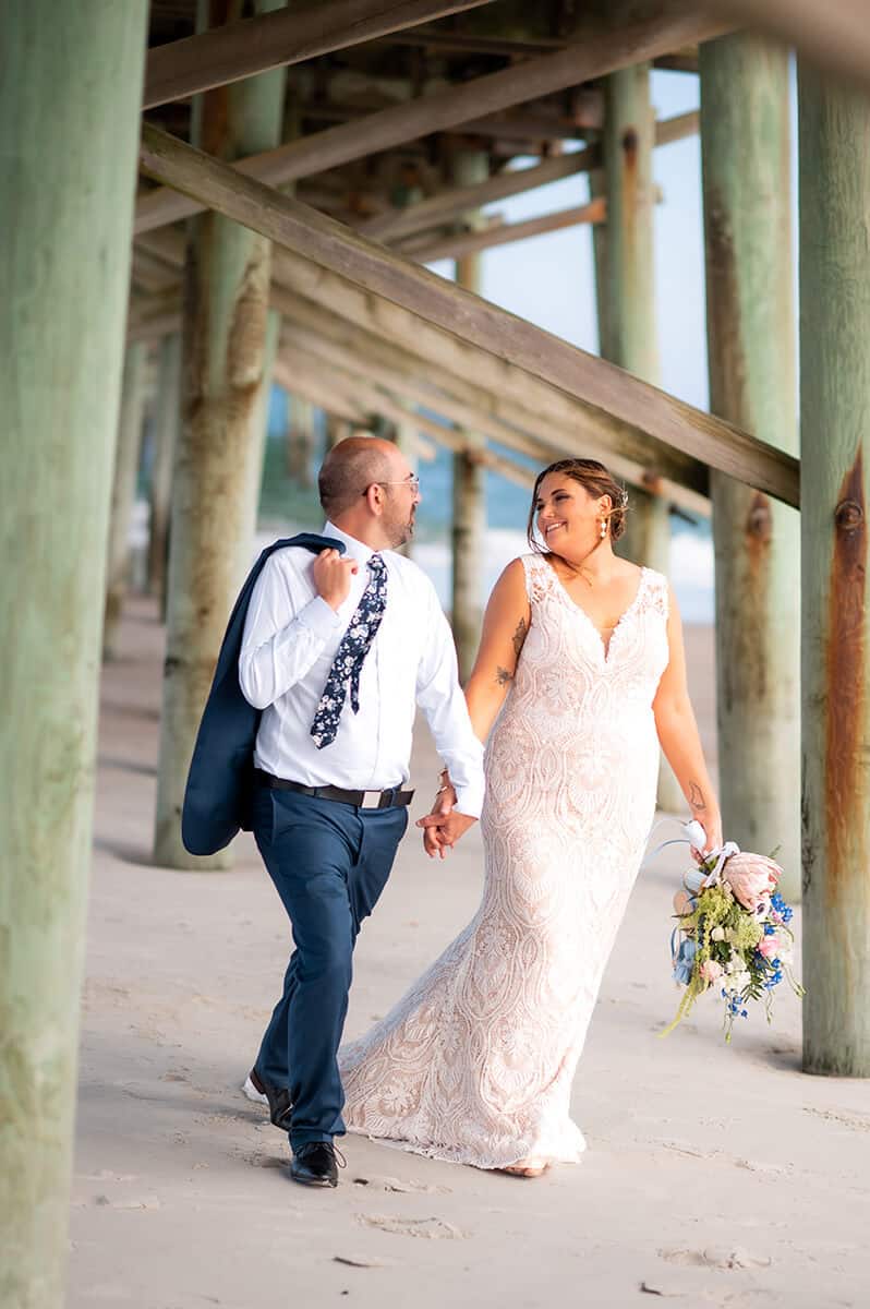 bride and groom under the Topsail Beach pier